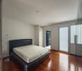 Spacious room, king-size bed, wooden floors, white walls, glass doors leading to a shower