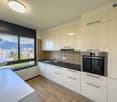 white cabinets, tiled floor, stainless steel appliances, large window with view