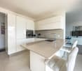 white cabinets, tile flooring, marble countertop, sink, oven, dishwasher, refrigerator, television, microwave