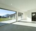large glass windows, balcony, tiled floor, white walls, glass railings