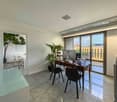 desk, two chairs, plant, tiled floor, large window, balcony, office furniture