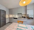modern kitchen with stainless steel fridge, gas stove, white cabinets, modern sink, and dishwasher