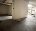 Empty garage with concrete floor, white walls, and ceiling