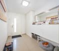 Entrance hallway with tiled flooring, built-in shoe storage, entrance mat, and mirror