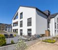 Modern white house, 3 floors, large windows, balcony, garden, patio with black railings