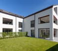 modern white house, 3 floors, multiple balconies, large windows, glass doors, garden, lawn