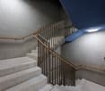 modern staircase with white marble steps, metal handrails, blue ceiling