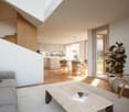 White room with wooden floor, stairs, open living dining area, glass door, wooden chairs, round table