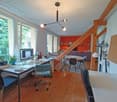 office desk, office chair, computer monitor, shelves, plants, radiator, large windows, dining table, dining chairs, round table lamp, coat rack