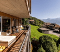 house on hillside, balcony, outdoor seating, lake view, mountains