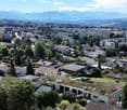Aerial view of a town with many houses, trees, and mountains in the background