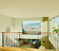 balcony with railings, large windows, view of the city, hanging lamp, potted plant