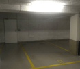 Empty parking lot with yellow lines, white walls, and a white door.