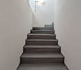 Gray tiled staircase, white walls, round ceiling light