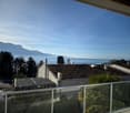 Balcony with glass railings, view of mountains and a body of water