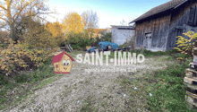 Wooden barn or shed, gravel path, trees with autumn foliage, outdoor equipment or storage