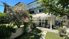 modern house with garden, paved walk way, plants and trees