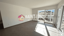 Large open room with gray tile flooring, white walls, and large windows providing natural light. The room features a prominent Saint-Immo real estate agency logo on the wall.