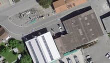 Multiple buildings and a lot of cars parked on an aerial view of the street.