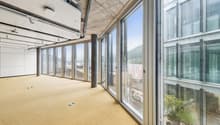 Wide windows with city view, carpeted floor, central column