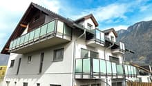 3 story house, white exterior, brown roof, multiple balconies, mountain view