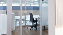 glass office space, open area with chairs and desks, metal swivel chair, glass wall and partition