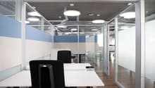 glass walls, white desk, black office chairs, ceiling lamps