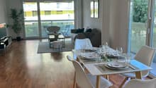 modern dining room with white chairs, wooden floor, dining table, open balcony, glass door