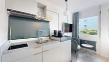Open plan kitchen, gas stove, stainless steel sink, extractor fan, television, chairs, radiator, windows
