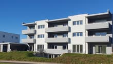 4 story building, white exterior, modern design, several balconies