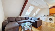 / a large room with a couch, table, and kitchen