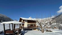 Mountain chalet with terrace, snow-covered, snowy mountains in background