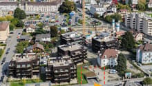 Aerial view of an urban area, residential buildings, a construction crane, and cars parked in lots