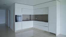 modern kitchen with white cabinets, stainless steel appliances, tiled floor, and a sink with a faucet