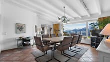 une grande pièce avec une table à manger et des chaises, avec une vue sur les montagnes depuis la cuisine et le salon / a large room with a dining table and chairs, with a view of the mountains from