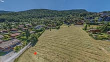 Plot of land for development in a mountainous area with several chalets, surrounded by forests and mountains
