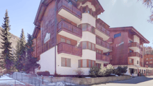 3 story building, wooden exterior, balconies, snow on the ground