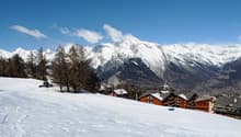 Winter mountain scenery, houses, snow-covered mountains, ski lift, clear blue sky