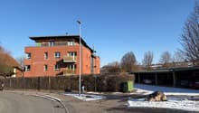 3 story brick building, balconies, street light, cars parked in garage
