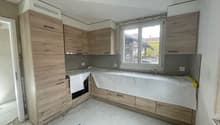 Wooden cabinets, white walls, white tiled floor, open window, under-construction.