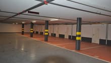 large open parking area, white walls, gray floor, columns, numbered parking spaces