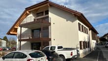 two-story house, cream colored walls, brown roof, balconies, parked cars