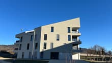 multi-story apartment building, concrete walls, glass windows, balconies