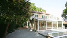 2-story house with a terrace and a glass-enclosed porch, raised ground floor with terrace