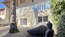 Traditional style building, large windows, wooden deck, Buddha statue, vine-covered facade