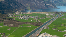 An aerial image of a land for a commercial project in Altdorf UR, featuring a landscape with a river, green fields, mountains, buildings, and a highlighted plot