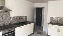 modern kitchen with black countertops, white cabinets, tiled floor, gas stove, modern sink with faucet, white walls, tile backsplash