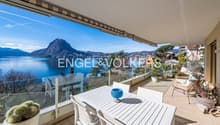 glass railing, large balcony, lake and mountain view, outdoor table and chairs, potted plants