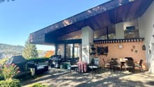 Modern building with outdoor seating area, covered terrace, barbecue, and garden. Located near city.