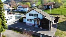 Detached house, white exterior, brown roof, attached garage, driveway, garden, multiple houses in the background